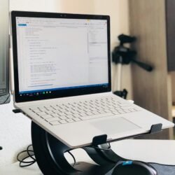 A home office setup featuring a laptop on a stand and a monitor, ideal for remote work.