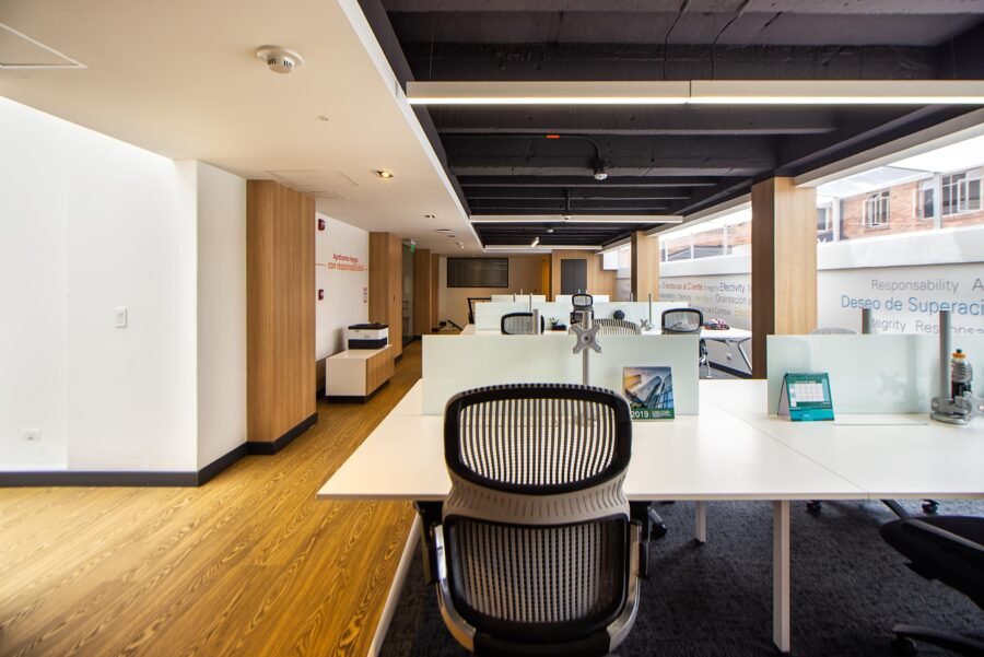 Spacious and well-lit modern open plan office with minimalist design and sleek furniture.
